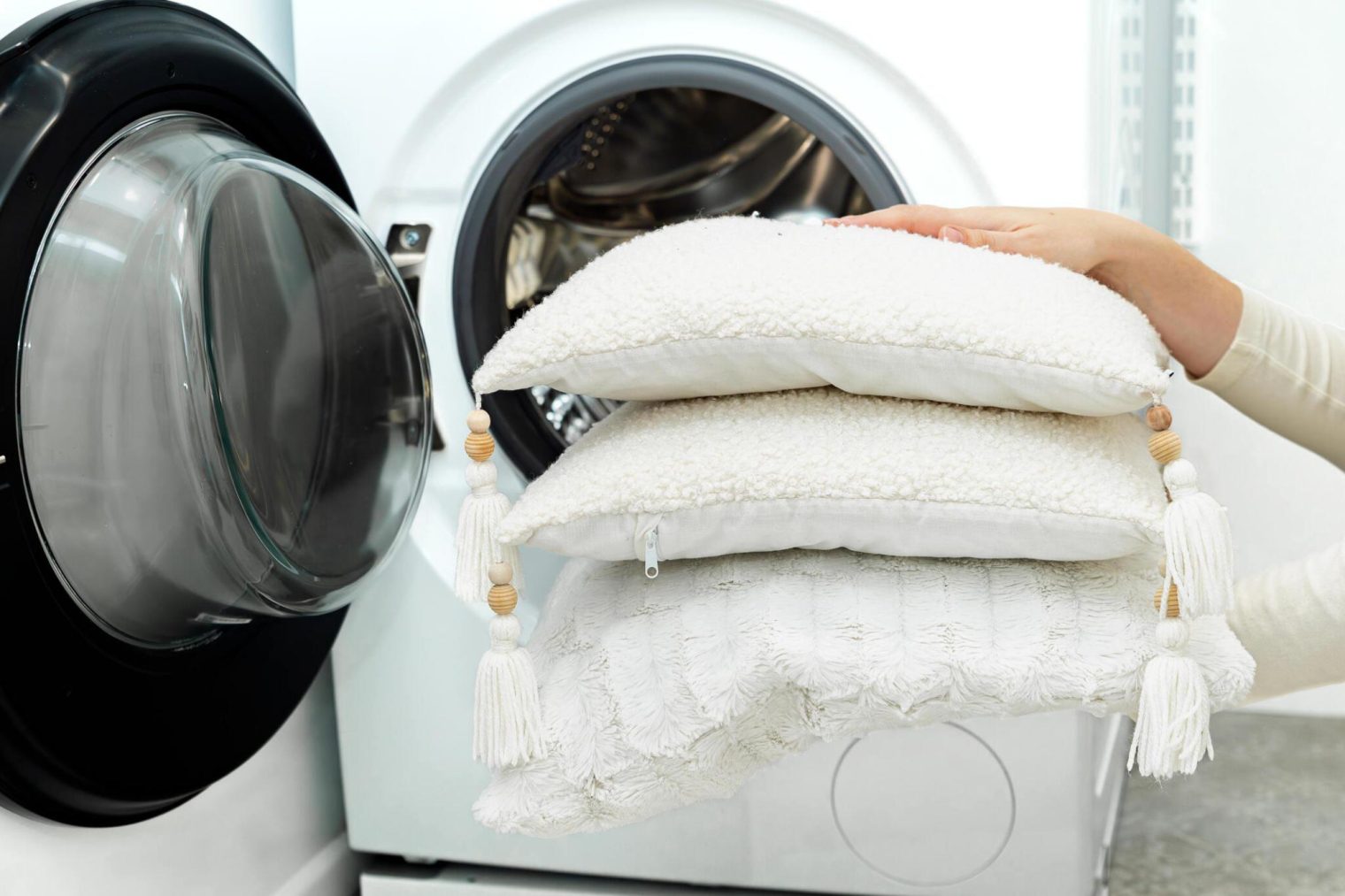 Two washable throw pillows balanced in a washing machine