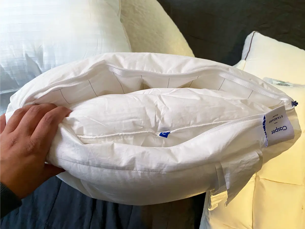 A flattened old pillow beside a newer pillow with more loft