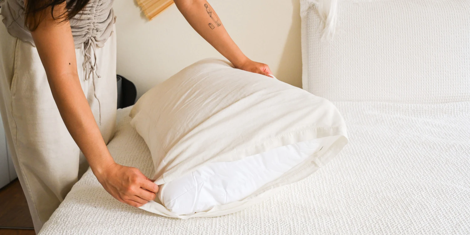 A clean pillow protected by a washable zippered pillow protector