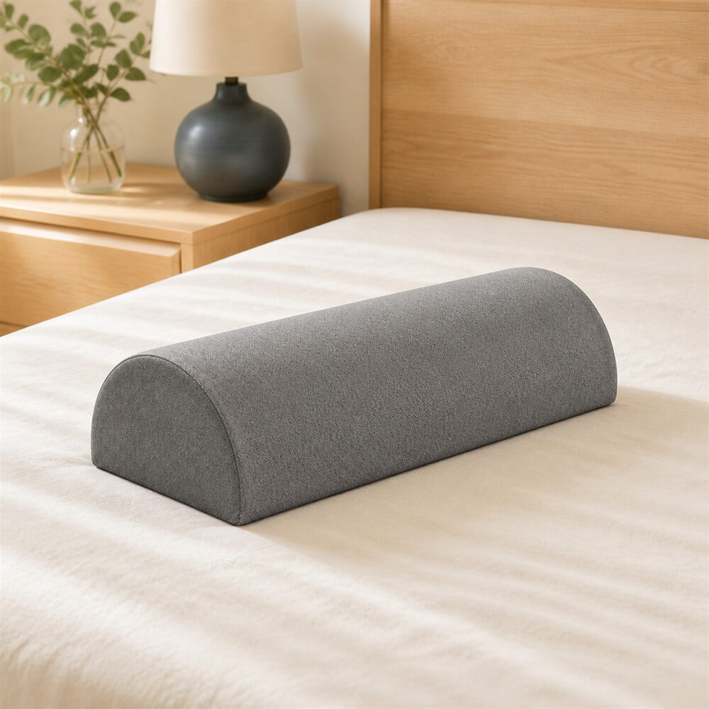 Grey half-moon bolster pillow on warm ivory bedding