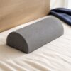 Grey half-moon foam bolster pillow on ivory bedding